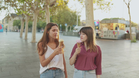 Two women enjoying ice cream outdoors, representing the joyful taste experience of MipaEssence flavours